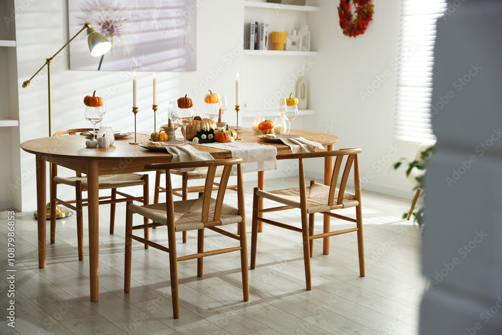 Stylish dining room with beautiful table setting and autumn decor Stylish dining room with beautiful table setting and autumn decor