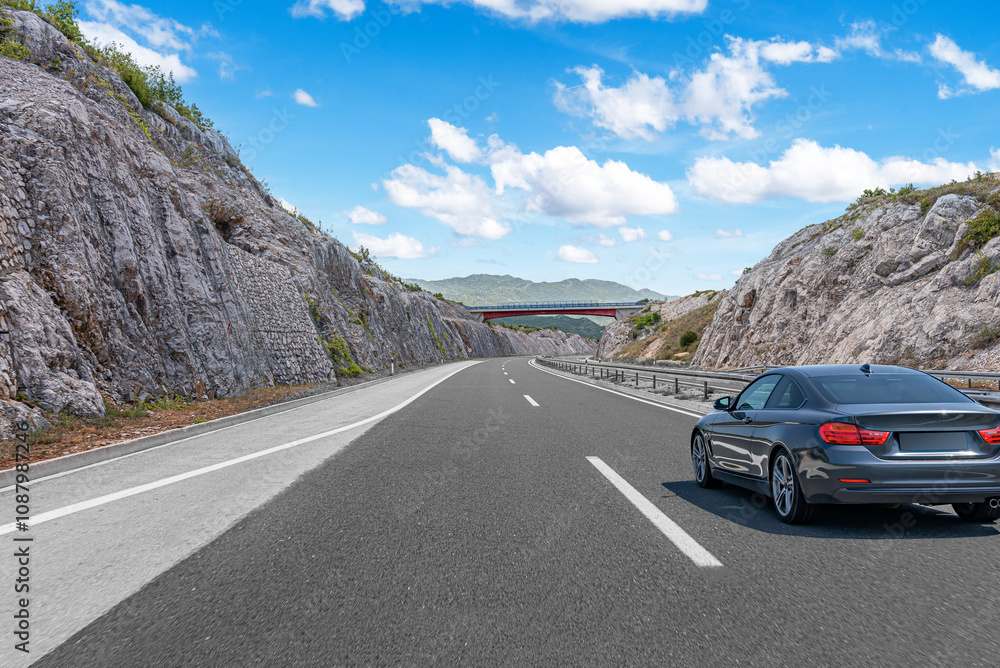 The car is driving along the highway surrounded by picturesque nature.