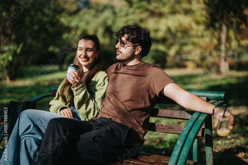 фотографія A cheerful couple sits on a park bench, savoring iced drinks and each others company on a sunny day