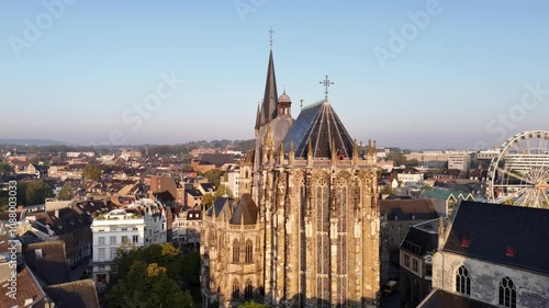 Drone footage of Aachen Cathedral on a sunny day with blue sky, surrounded by medieval architectures