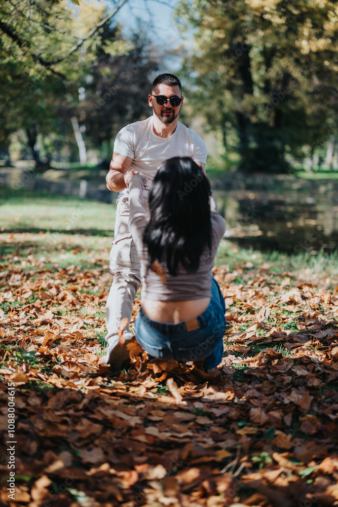 A joyful scene of a couple having fun in a park filled with autumn leaves. The man playfully pulls his partner, creating a moment of happiness and connection. A joyful scene of a couple having fun in a park filled with autumn leaves. The man playfully pulls his partner, creating a moment of happiness and connection.