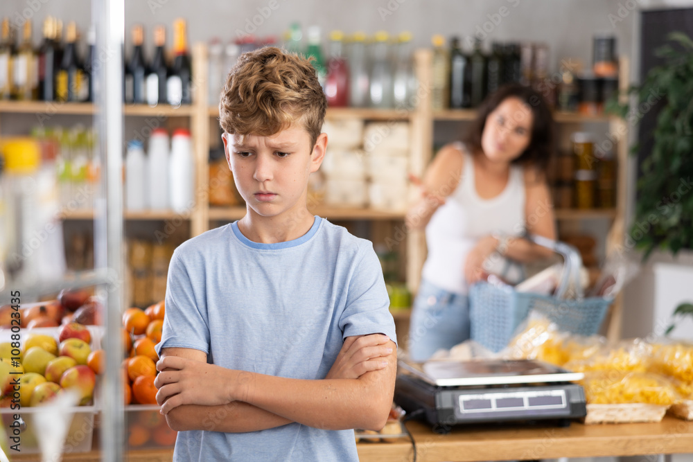 Unhappy boy quarrels with his mother in grocery store Unhappy boy quarrels with his mother in grocery store