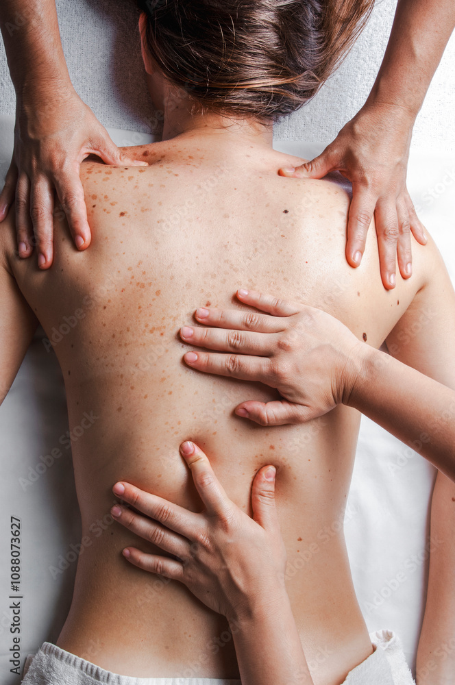 Four hands massage on woman's back, promoting relaxation and wellness Four hands massage on woman's back, promoting relaxation and wellness