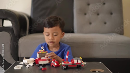 Portrait of an Indonesian boy assembling a toy while playing at home.
