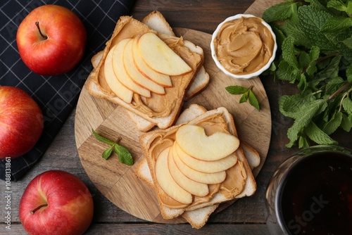 Tasty sandwiches with peanut butter, apples, mint and tea on wooden table, flat lay photo