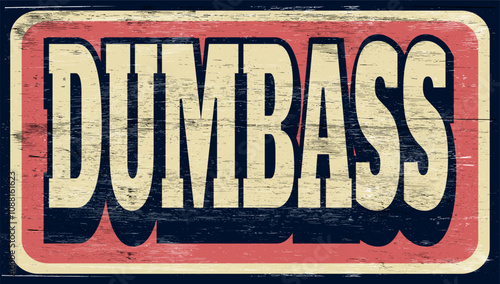 Aged and worn dumbass sign on wood