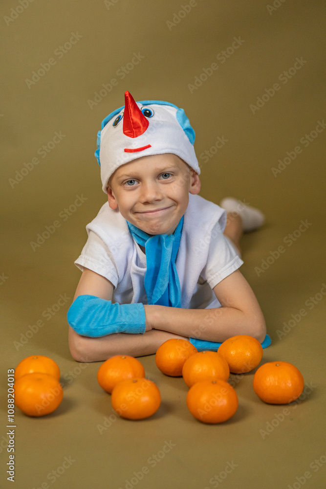 boy in a snowman costume lies with tangerines boy in a snowman costume lies with tangerines
