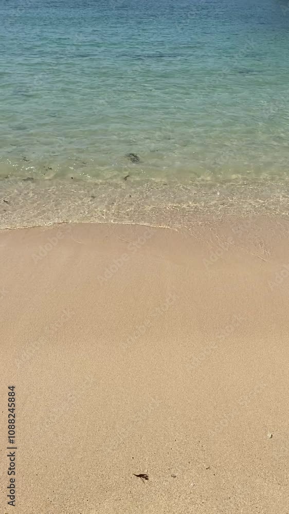 Vertical video the atmosphere of small waves on a white sand beach Vertical video the atmosphere of small waves on a white sand beach