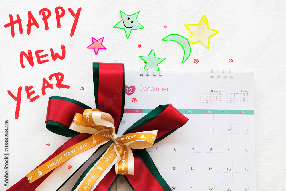 happy new year message card with ribbon, calendar, star arrangement flat lay postcard style on background white happy new year message card with ribbon, calendar, star arrangement flat lay postcard style on background white