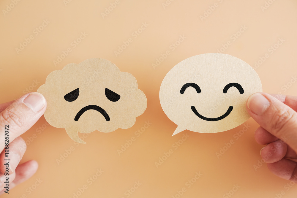 Fototapeta premium Hands holding happy and sad face on speech bubble paper, World mental health day, Psychology and speech therapy concept
