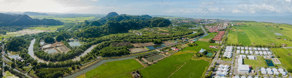 Panoramic aerial drone view of residential area near green paddy crops land at Kampung Wai, Perlis, Malaysia Panoramic aerial drone view of residential area near green paddy crops land at Kampung Wai, Perlis, Malaysia