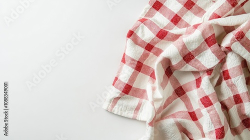 Red and white checked kitchen towel draped casually on a clean white background, showcasing a soft texture and vibrant pattern.