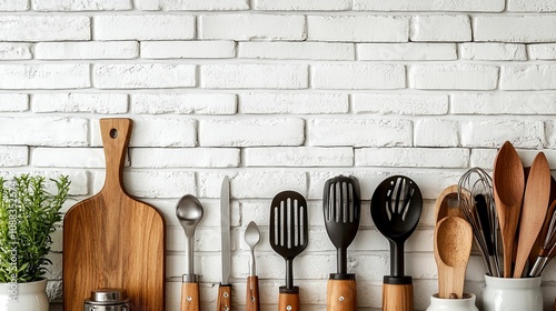 Wooden and Metal Kitchen Utensils Against White Brick Wall photo