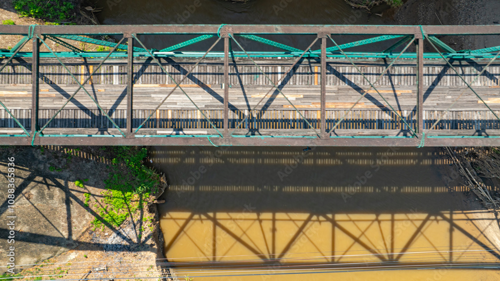 Aerial view of The historic Tha Pai Bridge, spanning the Pai River, is about a hundred years old and was built during World War II. Surrounded by rice fields, it is a landmark before entering Pai, Aerial view of The historic Tha Pai Bridge, spanning the Pai River, is about a hundred years old and was built during World War II. Surrounded by rice fields, it is a landmark before entering Pai,