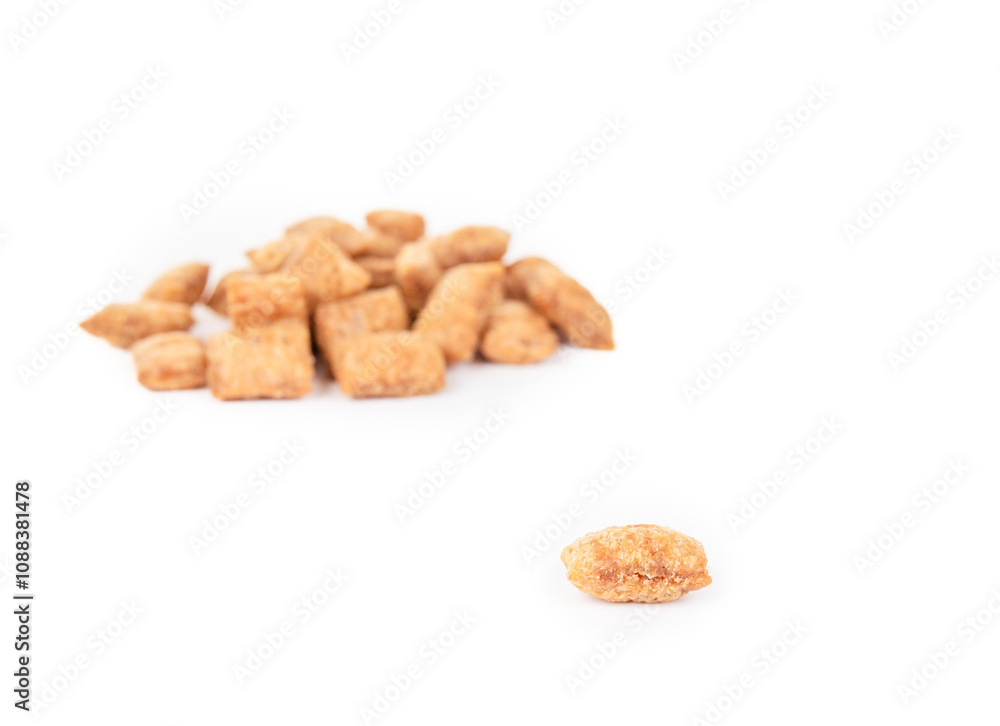 Cat treat with defocused pile. Heap of dry chicken treat or snack for cats or dogs. Used for rewards, training or obedience. Yellow brown crunchy dry pet food. Selective focus. White background. Cat treat with defocused pile. Heap of dry chicken treat or snack for cats or dogs. Used for rewards, training or obedience. Yellow brown crunchy dry pet food. Selective focus. White background.