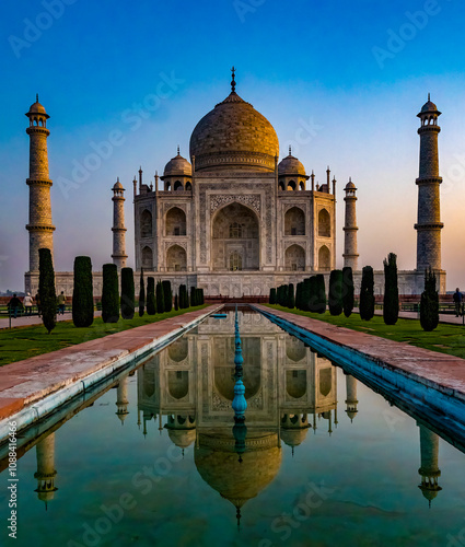 The iconic taj mahal basks in the early morning light, reflecting in the tranquil waters