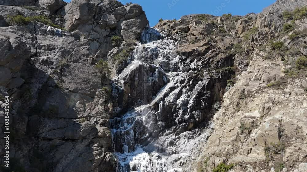 Picturesque waterfall with ice in rocky mountain on Route 40, San Martin de los Andes, Patagonia, Neuquén, Argentina Picturesque waterfall with ice in rocky mountain on Route 40, San Martin de los Andes, Patagonia, Neuquén, Argentina