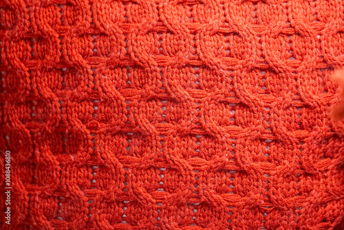 Close up of a red knit sweater with a pattern of circles