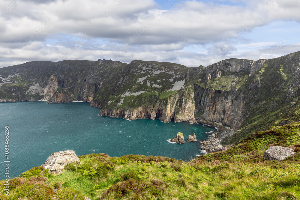 Slieve League cliffs in Ireland overlooking the Atlantic Ocean, showcasing rugged coastline, steep cliffs, and lush green landscape Slieve League cliffs in Ireland overlooking the Atlantic Ocean, showcasing rugged coastline, steep cliffs, and lush green landscape