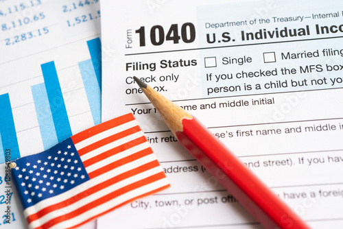 Tax Return form 1040 with USA America flag and dollar banknote, U.S. Individual Income. photo