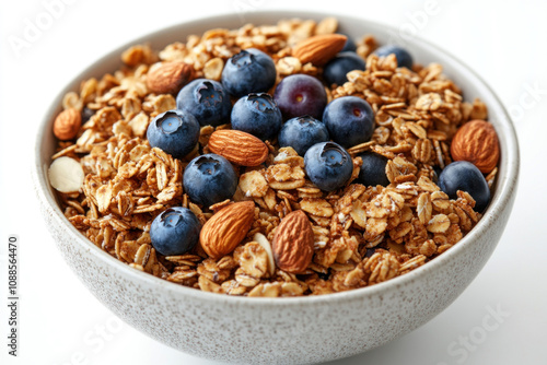 Bowl of granola topped with blueberries and almonds on a wooden table.