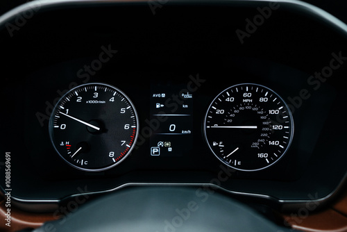 Modern brown car interior, leather steering wheel, climate control, large navigation screen, air ducts, deflectors on the car panel. Interior details. photo