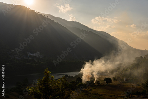 Village view at Chinyalisaur by the Bhagirathi River, stubble burning with smoke causing pollution in agricultural fields. photo