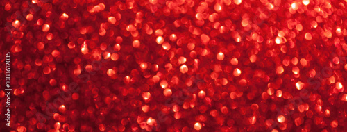 Blurred red sparkling background from sequins, macro. Shiny ruby glittery bokeh of christmas garland.