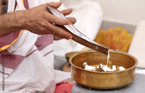 Performing Pooja for Hindu god siva linga with milk, honey and coconut water	
 photo