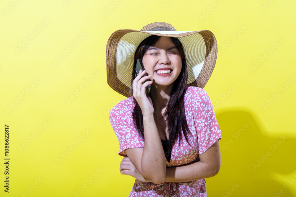 Asian woman in a pink floral dress, wearing a wide-brimmed straw hat, talking on a smartphone with a cheerful and expressive look, set against a vibrant yellow background, radiating positivity Asian woman in a pink floral dress, wearing a wide-brimmed straw hat, talking on a smartphone with a cheerful and expressive look, set against a vibrant yellow background, radiating positivity