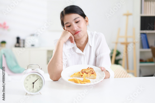 Weight loss concept. Girl refuses to eat pizza on a plate at home. Hand pushes away. Refuses junk food or fast food. Trying to not get fat. Healthy nutrition for weight loss.