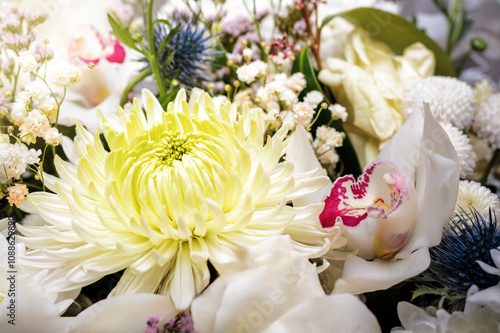 White bouquet of different flowers with a chrysanthemum flower in the center