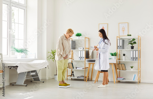 A doctor, nutritionist, or nurse weighs an elderly patient on a scale during a clinic examination. Health assessment, ensuring the patient well-being through regular monitoring and care. photo