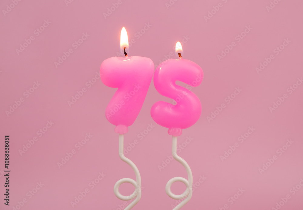 Pink air balloon shaped birthday candles burning on pink background. Number 75. Pink air balloon shaped birthday candles burning on pink background. Number 75.