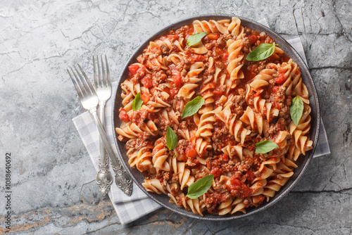 Obraz na płótnie Italian fusilloni pasta or large fusilli with bolognese sauce close-up in a plate on the table. Horizontal top view from above w salonie