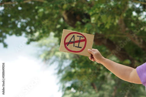 Photography Close up hand holds paper card with No AI,  prohibition sign, outdoor nature background