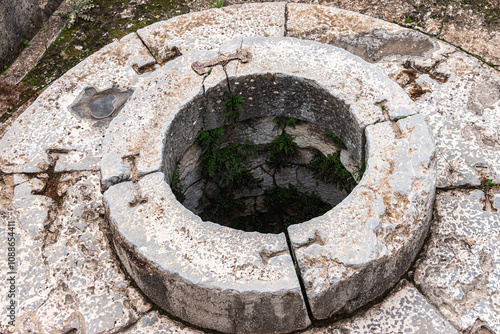 Close-up of an ancient stone well (Well of fair dances). Historical and archaeological site of Eleusinian Sanctuary. Elefsina, Attica, Greece photo