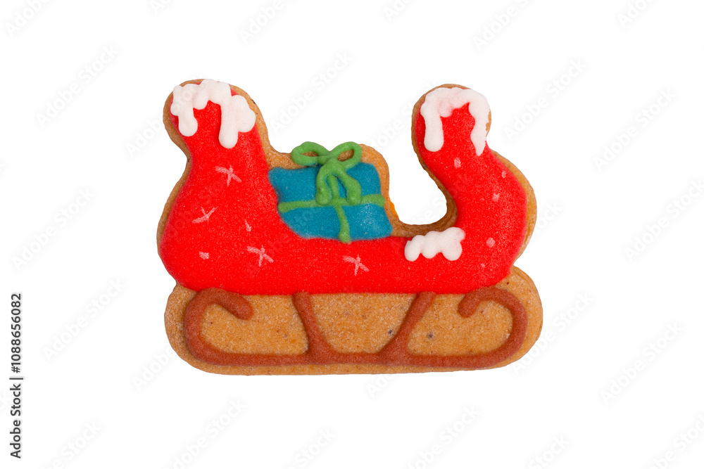 Naklejka premium Homemade gingerbread colored cookie „Sleigh with gift bag“ on white, isolated Christmas handmade gingerbread cookie „Sleigh with gift bag“ on white background, Christmas dessert, top view, flat lay