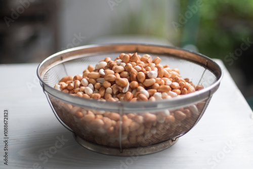 After soaked and cleaned peanuts (groundnut, goober pea, pindar, or monkey nut) in basket isolate on white table close up selective focus photo