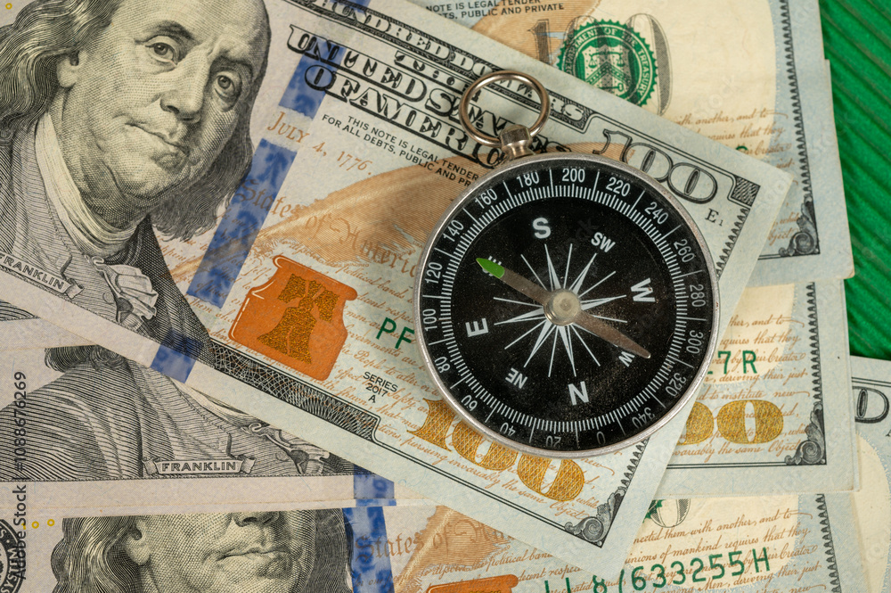 Compass on 100 dollar bill, financial management concept photograph Compass on 100 dollar bill, financial management concept photograph