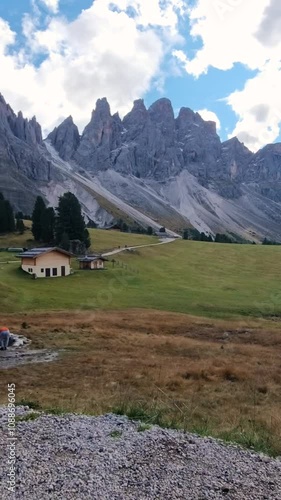 Wallpaper Mural Witness the captivating beauty of the Dolomites mountains as golden sunlight casts dramatic shadows over lush green meadows. Nature's palette is on full display in this serene landscape. Torontodigital.ca