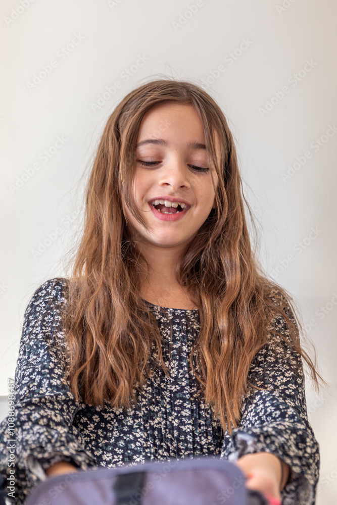 Happy girl is packing a backpack for school. The girl goes to school. Happy girl is packing a backpack for school. The girl goes to school.
