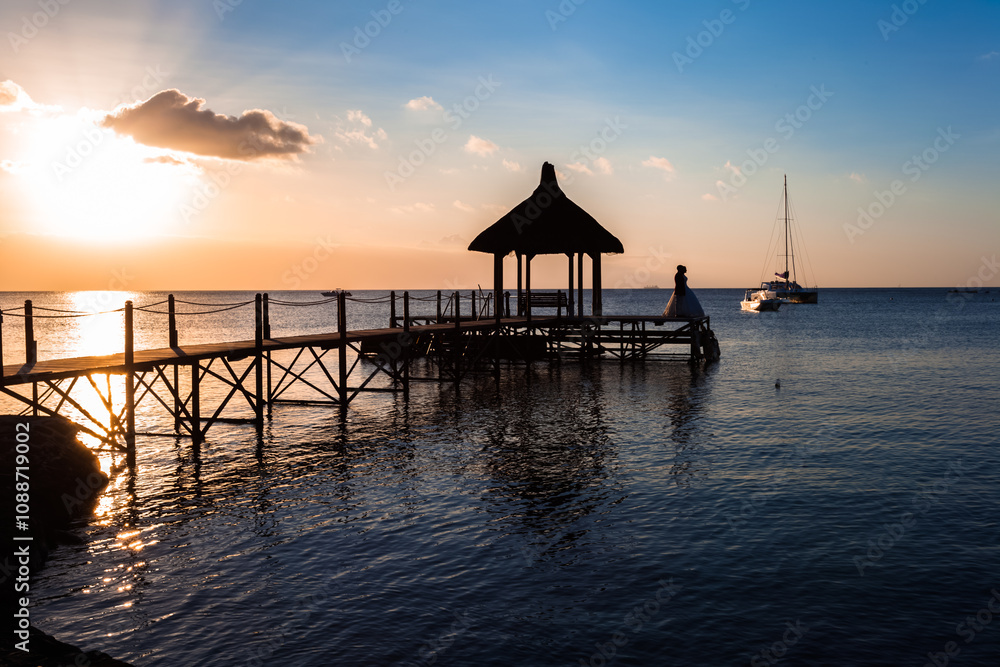 Couple sur ponton au coucher du soleil, île Maurice Couple sur ponton au coucher du soleil, île Maurice