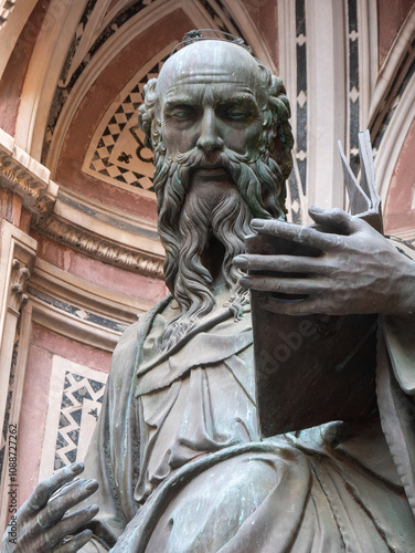 The bronze statue of St. John the Evangelist from the year 1515 by Baccio da Montelupo in the external niches of the church of Orsanmichele in Florence, Italy. photo