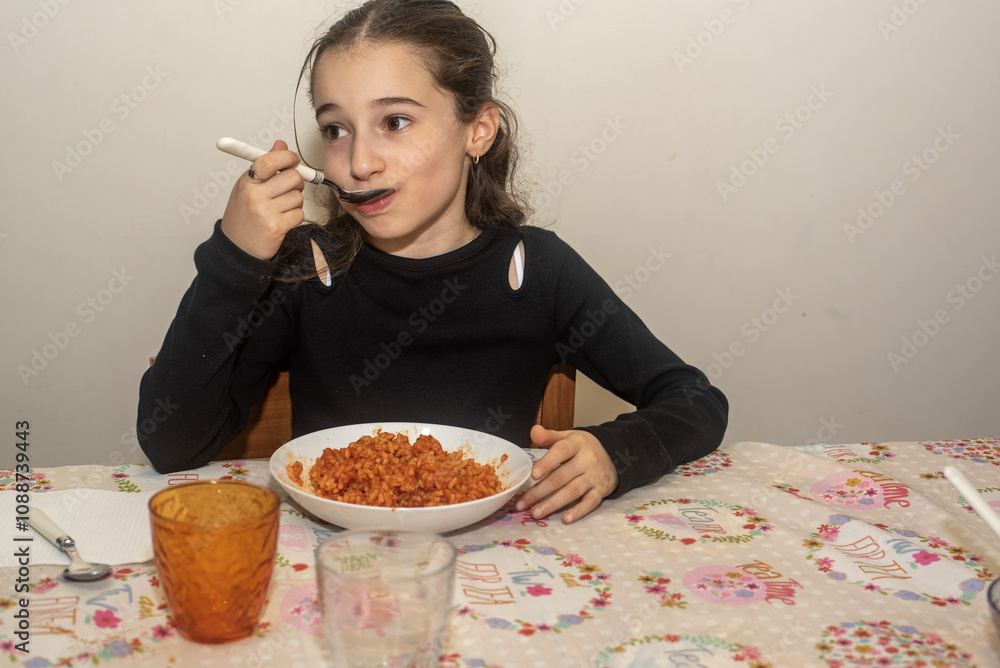 Bambina di dieci anni mentre mangia un piatto di orecchiette al sugo. Bambina di dieci anni mentre mangia un piatto di orecchiette al sugo.