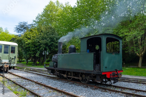 A green train with smoke coming out of the top of it photo