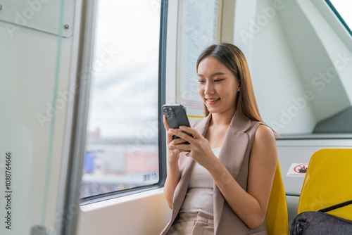 Free Download Young Asian Businesswoman Using Phone While Commuting In A Public Skytrain To Work  - GFXLoad