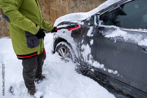 Obraz na płótnie Person Clearing Snow from Car in Winter Landscape w salonie