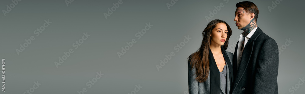 A young couple stands confidently together, showcasing their trendy outfits in an artistic setting. A young couple stands confidently together, showcasing their trendy outfits in an artistic setting.