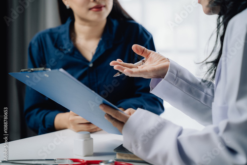 Fotografie Doctor Patient Consultation:  A close-up shot of a doctor and patient engaged in a serious, focused discussion, reviewing medical documents
